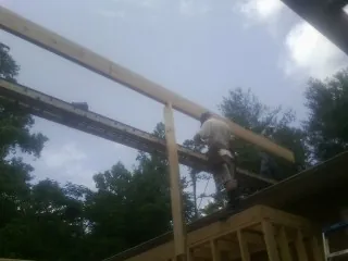Carpenter setting a ridge beam over a new addition frame — Ice Dam Removal by Roofing Brothers in Turtle Lake