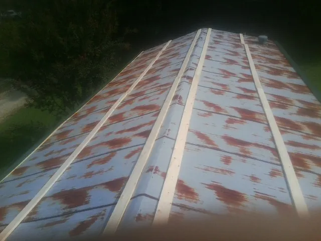 Rusted metal roof panels with new wood purlins before replacement — Storm Damage Roof Repair in Turtle Lake by Roofing Brothers